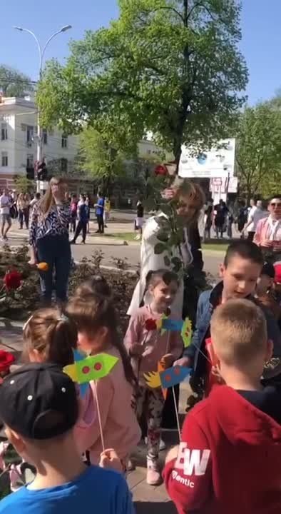 Вице-спикер Галина Антюфеева и депутат Верховного Совета Илона Тюряева раздают цветы детям, потом все вместе возлагают к бюсту Гагарина