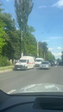 На Правде бригада скорой помощи оказывает помощь мужчине, лежащему на газоне