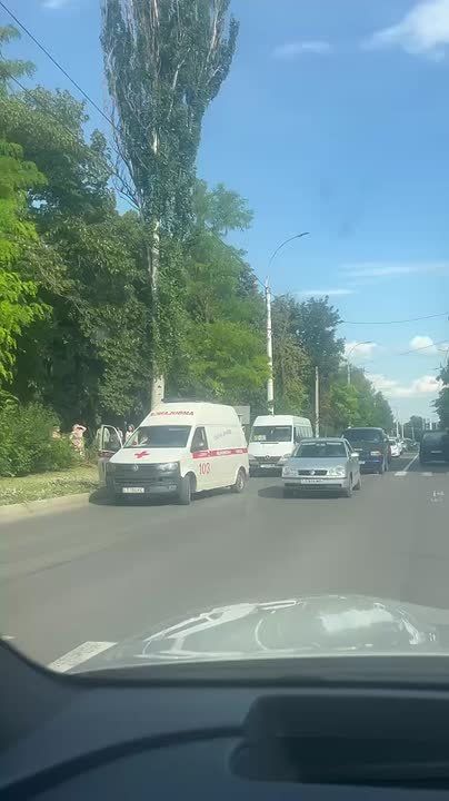 На Правде бригада скорой помощи оказывает помощь мужчине, лежащему на газоне
