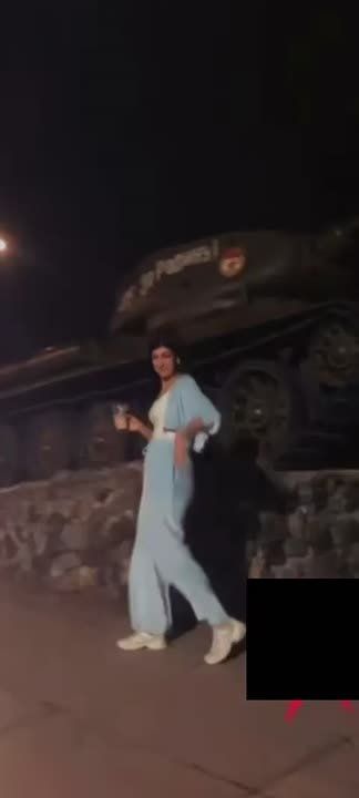 Девушка тверкает возле танка